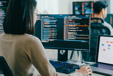 Woman coding on a computer at a desk